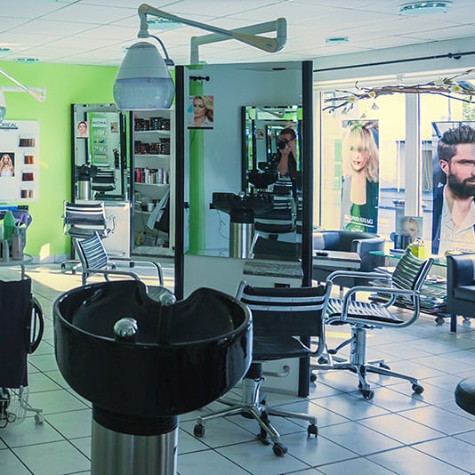 Blick in den Salon mit gr&uuml;ner Wand, Waschbecken und Bedienpl&auml;tzen